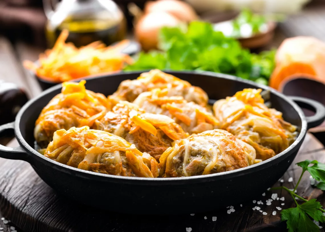 Cabbage Rolls Stewed With Meat And Vegetables In Pan On Dark Wooden Background