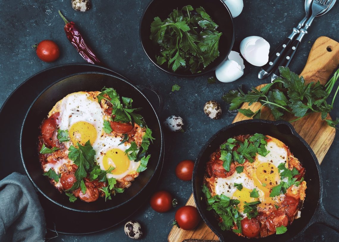 Breakfast Consist Of Two Pans With Fryed Eggs And Tomatos Overhead Shot Dark Surface