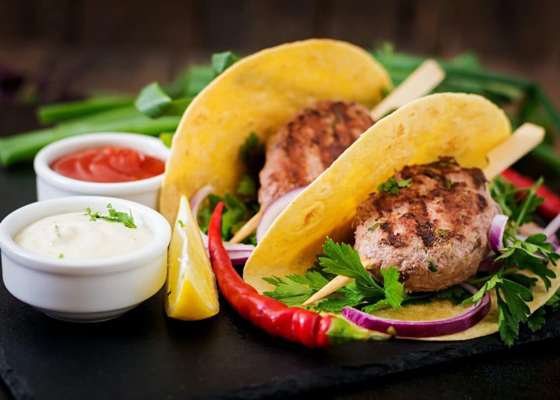 Tortillas Tacos With Appetizing Kebab Meatballs And Sauce On Black Background