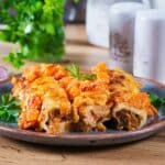 Meat cannelloni pumpkin-tomato sauce on plate.