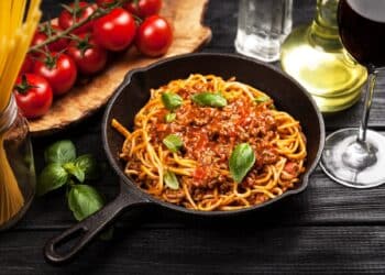 Easy Turkey Spaghetti Sauce In A Skillet Top With Extra Sauce And Basil Leaves