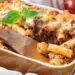 Easy Baked Ziti With Meat Sauce In A Brown Ceramic Oven Pan