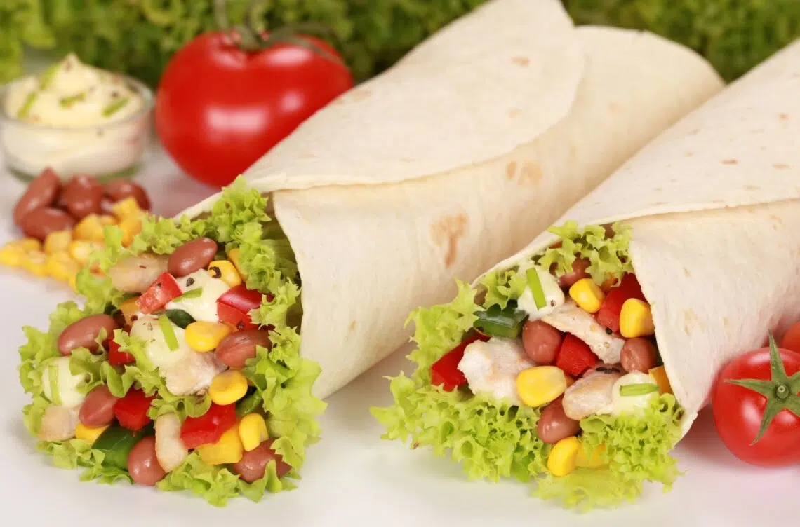Healthy Chicken Wrap Recipe With Tomatoes, Corn, And Lettuce In The Background