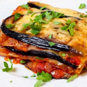 A Slice of Healthy Primal Lasagna on a White Plate with Garnish