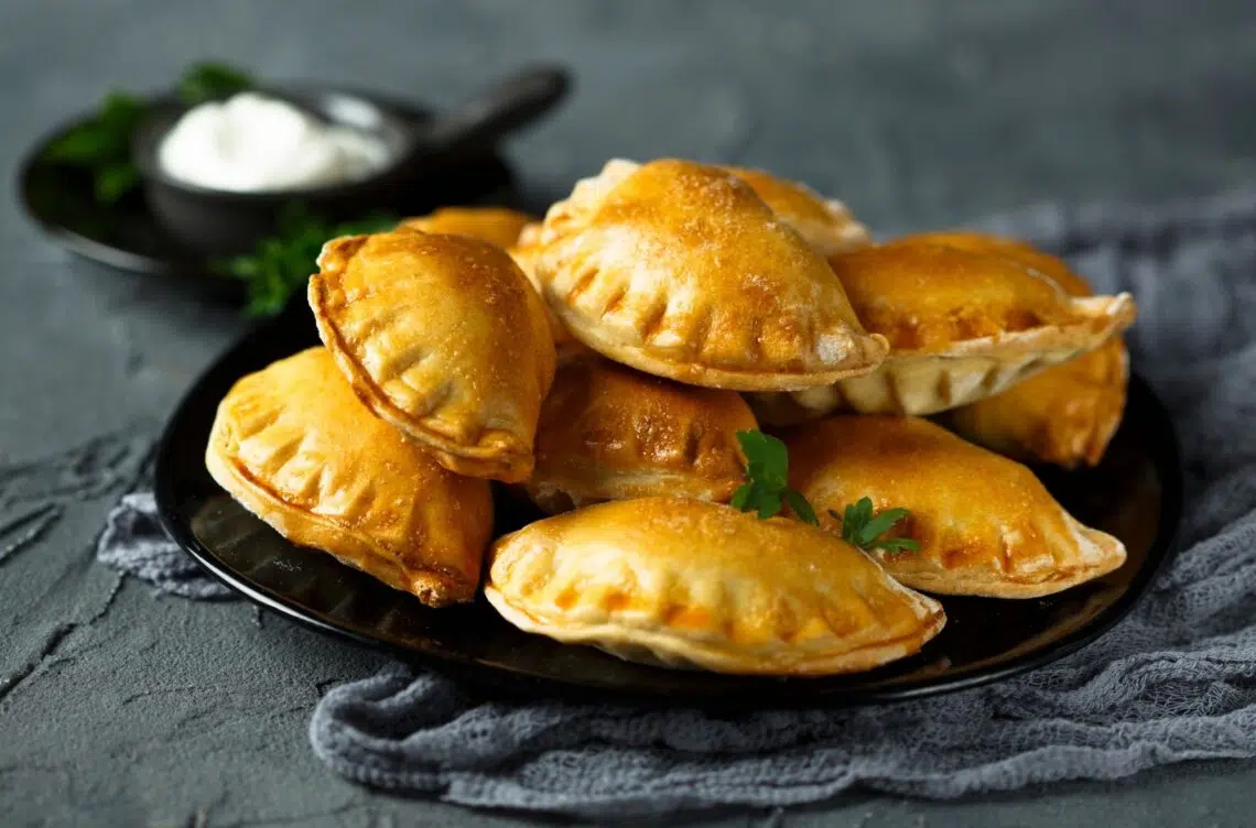 Stack Of Empanadas With Beef On A Black Plate