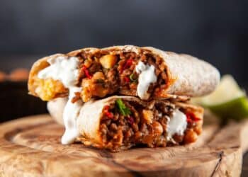 The Best Beef And Veggie Burrito Sliced In Half Exposing The Beef Mixture