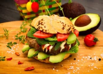 Best Ever Paleo Avocado Burgers With Slices Of Tomatoes, Avocados, Lettuce, And Arugula