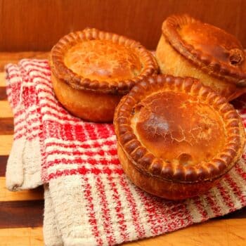 Three Pieces of Captivating Spiced Pork Pie-lets On A Kitchen Towel