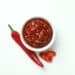 Red chili pepper and sauce on white background