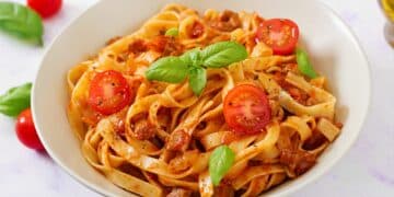 Delicious Homemade Fettuccine Bolognese With Slices Of Tomatoes And Basil Leaves